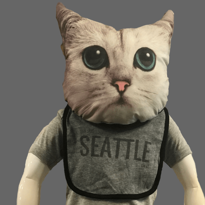 A mannequin with a cat head is wearing a grey bib that says "This Says Seattle On It"