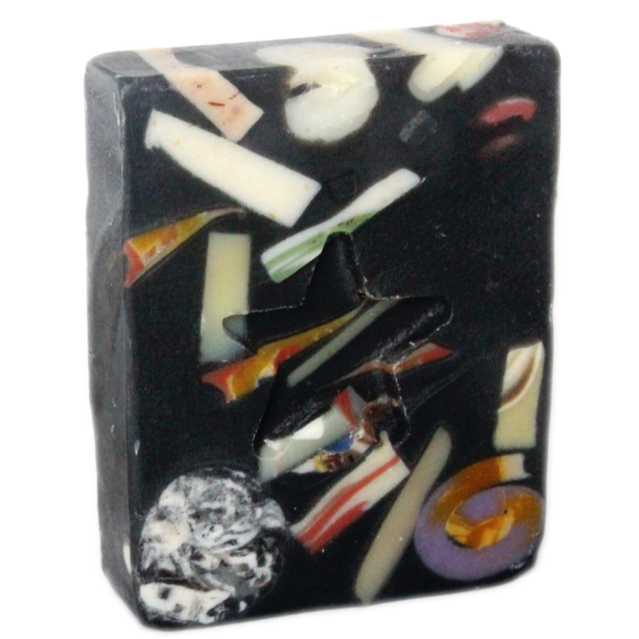 A bar of handmade soap with a variety of colors and patterns, including white, orange, and black.
