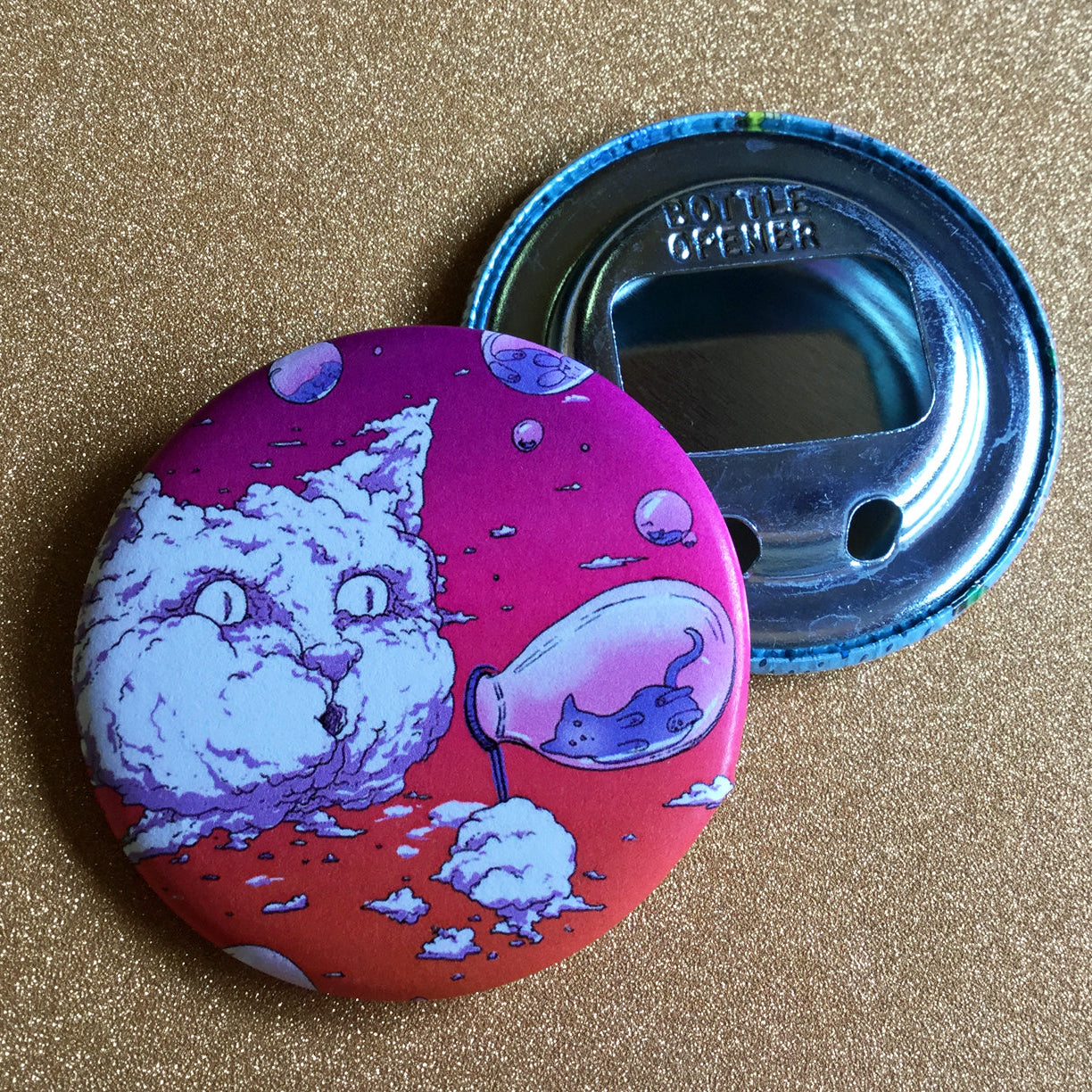Bottler opener with Bubble Cat design in sunset colors on a glittery surface.