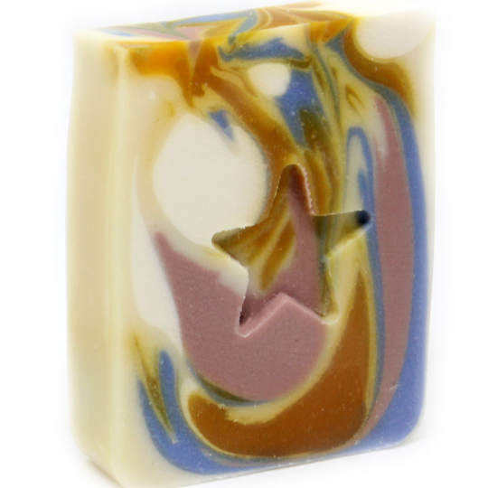 A bar of handmade soap with a swirl pattern and a cut-out star shape on top, displaying various colors including white, blue, brown, and green.