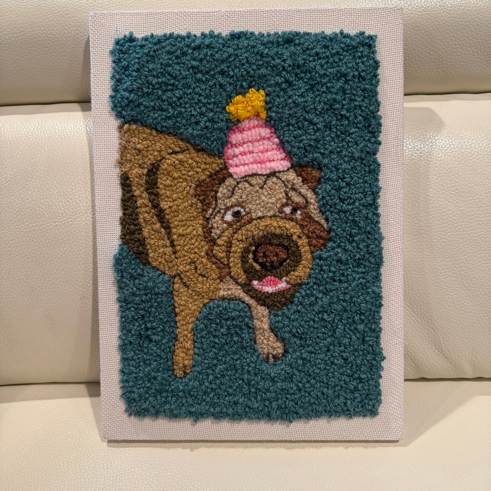 Decorative wall art of a dog wearing a party hat on a blue background.