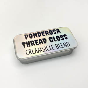 A metal tin of Ponderosa Thread Gloss - Creamsicle Blend - against a white background.