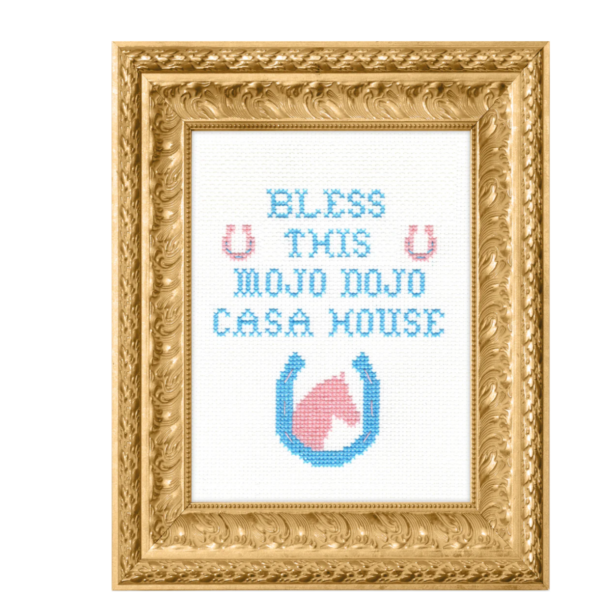 A finished cross stitch framed in an ornate gold frame. The cross stitch says "Bless this Mojo Dojo Casa House" and has a horse and horse shoe at the bottom. 