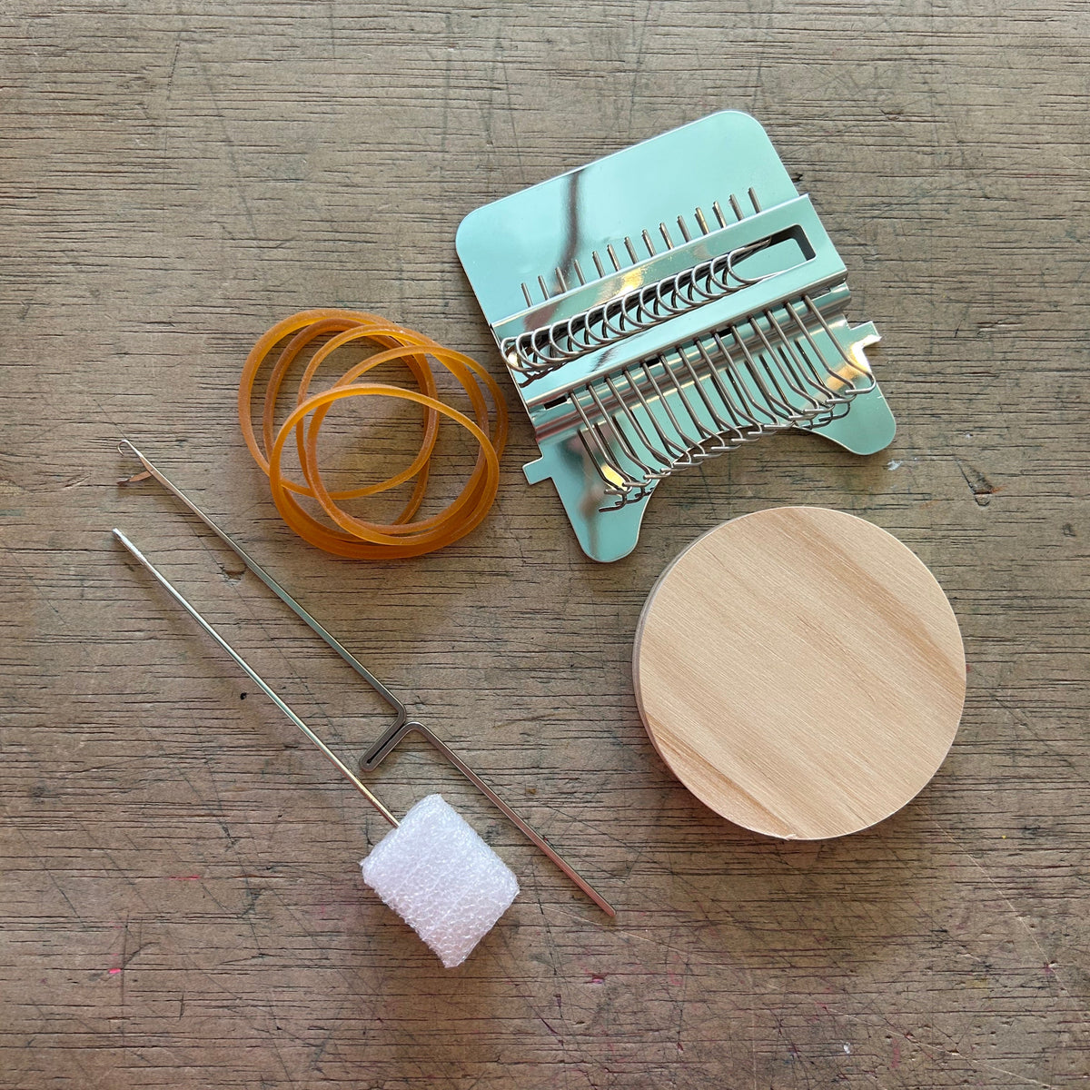Set of weaving tools on a wood background.