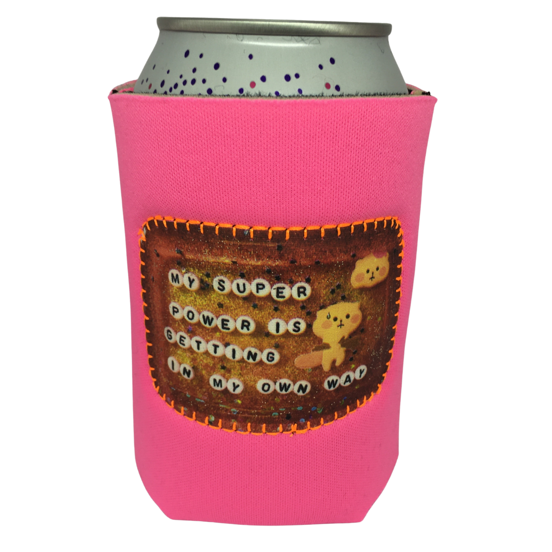 A pink can cooler with a patch on the front that says "My super power is getting in my own way."