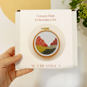 Canyon Park Embroidery Kit held by a hand with a scenic design on the packaging.