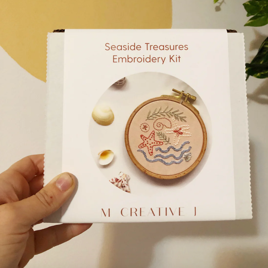 Seaside Treasures Embroidery Kit packaging held by a hand. 