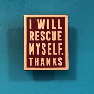 Maroon enamel pin with rose gold text that says I Will Rescue Myself, Thanks against a teal background. 