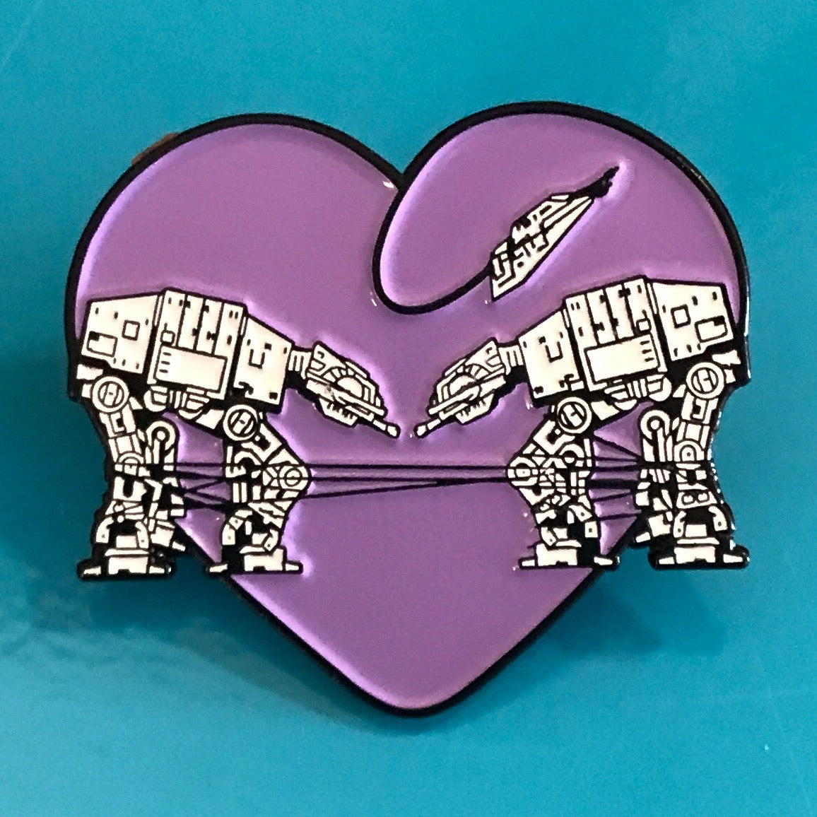 Heart shaped enamel pin called Love AT-AT First Sight with a purple background.