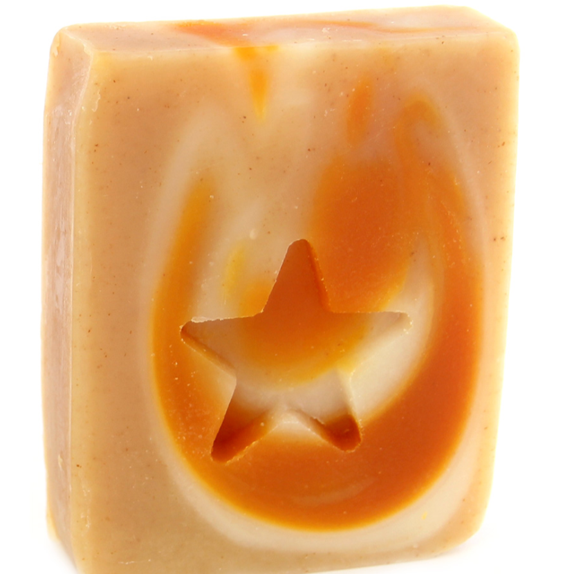 A bar of handmade soap with a star cut-out in the center, featuring swirls of orange and beige colors.