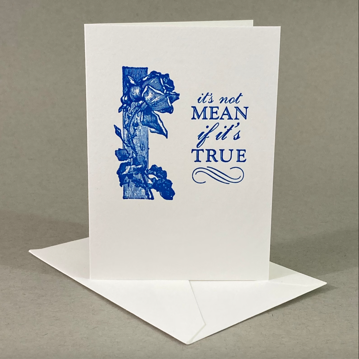 Greeting card with blue floral design and text on a gray background that says, "It's not mean if it's true."