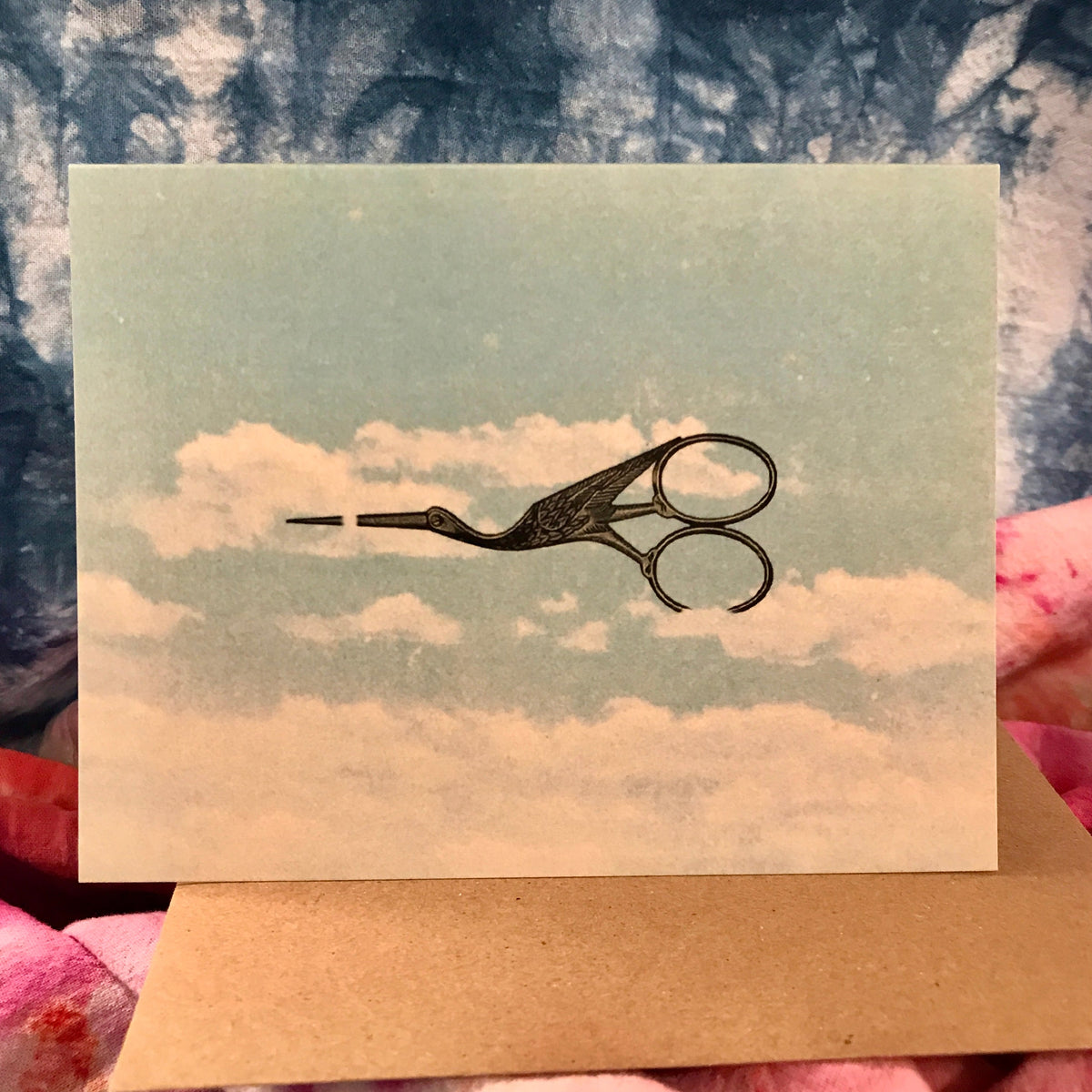Stork embroidery scissors on a card with a cloud pattern