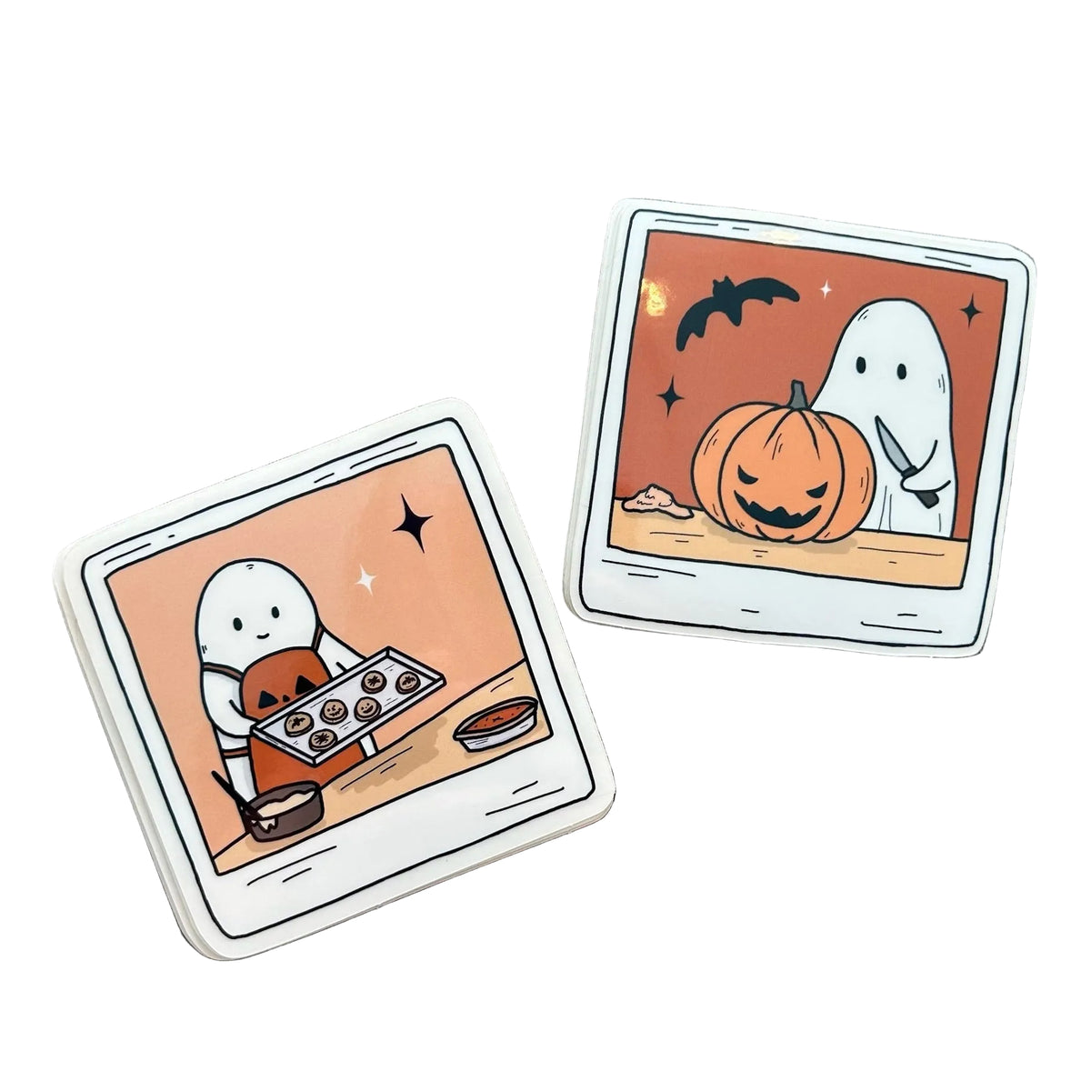 Two illustrations of polaroid images - one is a ghost baking cookies and the other is a ghost carving a pumpkin. They are both vinyl stickers. 