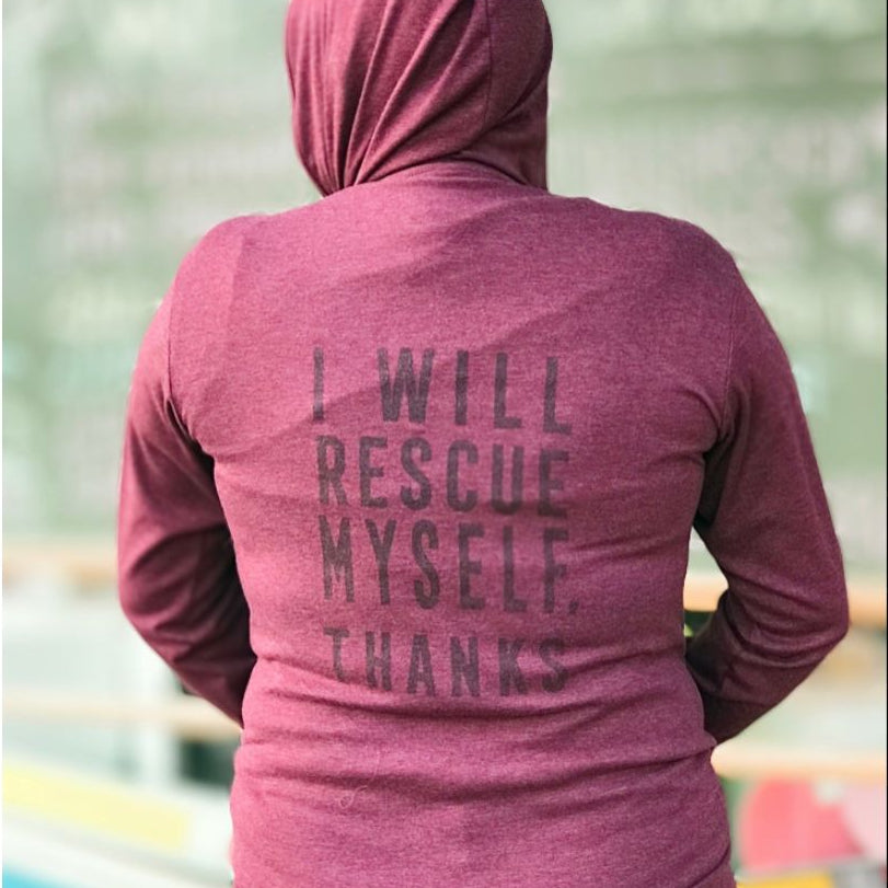 Person wearing a maroon hoodie with text on the back that says, "I will rescue myself, thanks" standing in an outdoor setting.