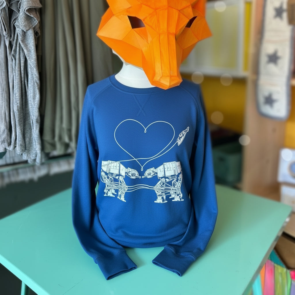 Mannequin wearing a blue sweatshirt with Love AT-AT First Sight design and an orange fox mask in a store setting.