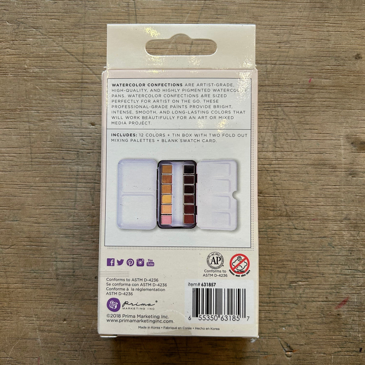 Back of a watercolor set packaging on a wooden surface
