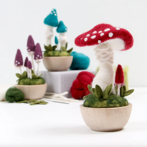 Three different mushroom needle felting kits displayed against a white background. 
