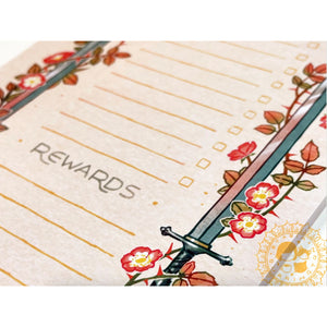 Notebook with floral design and sword, labeled 'Rewards', on a white background.