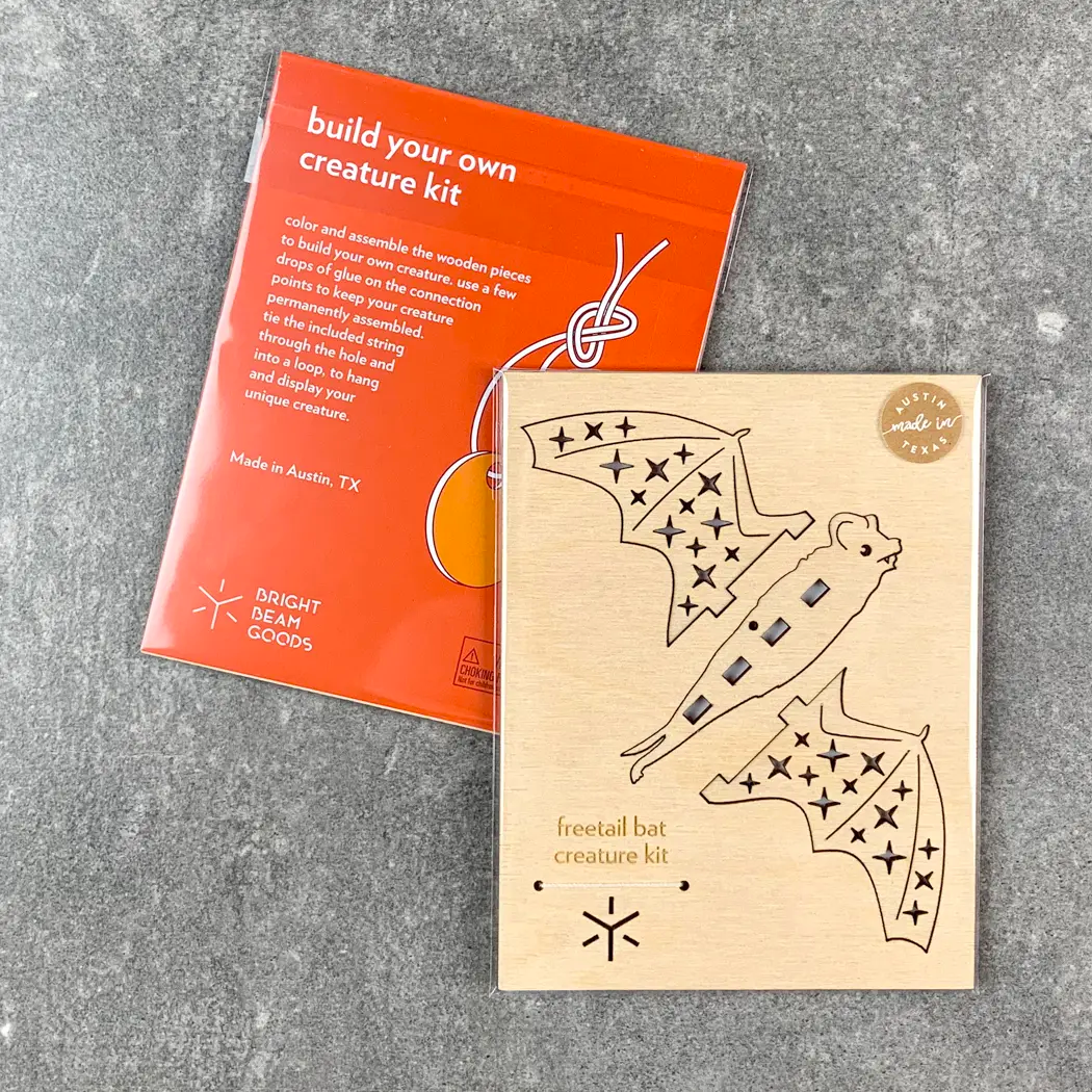 Packaging of freetail bat wooden craft kit by Bright Beam Goods. It shows the flat packed kit with the parts that are ready to be painted and assemble.d. 