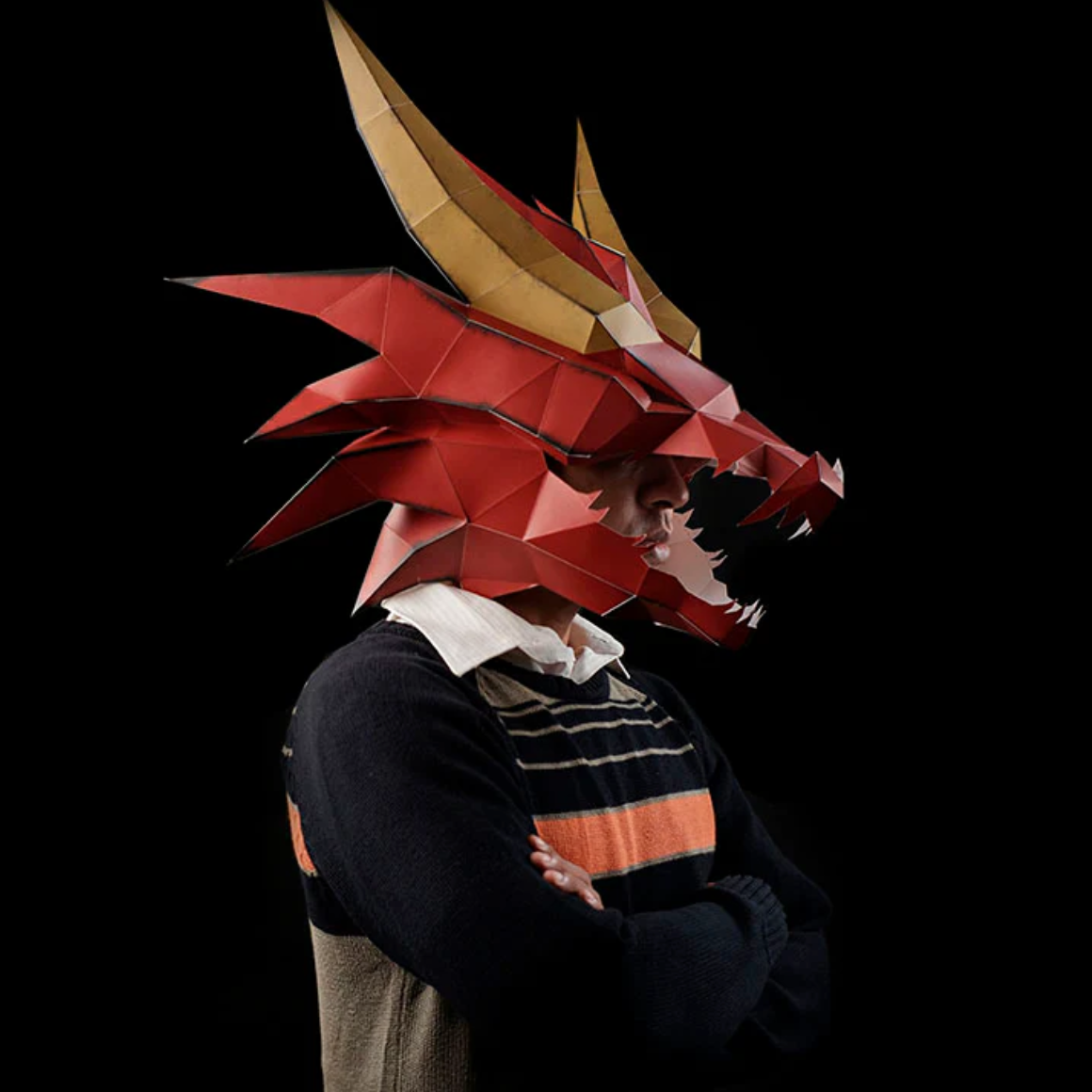 A person wearing a completed example of a dragon mask paper craft kit.