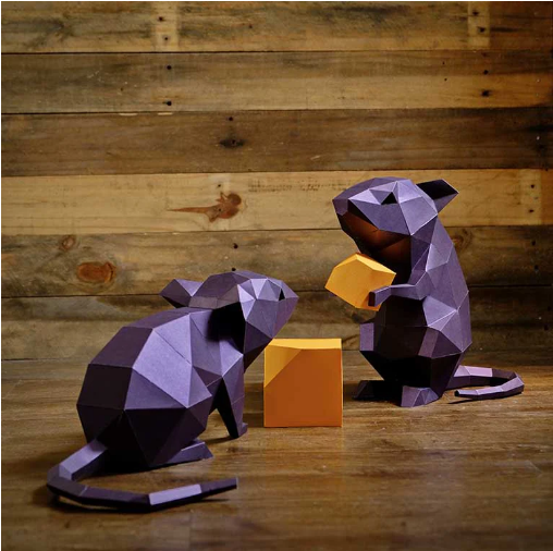 Examples of two completed mice and cheese. They are sitting on a wood table.