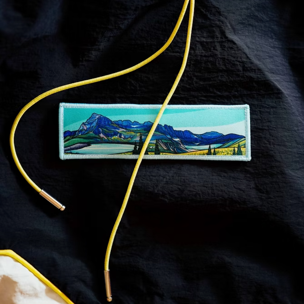 Embroidered patch of a mountain landscape on a black fabric background