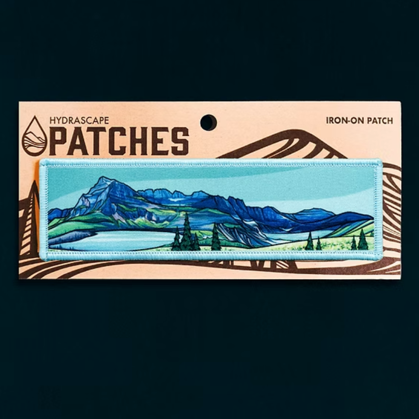 Iron-on patch with mountain landscape design on a Hydrascape Patches card.