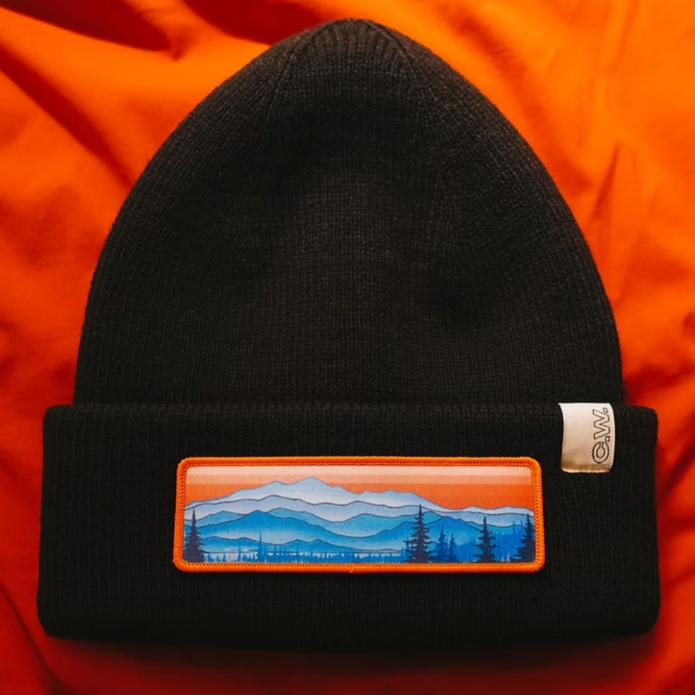 Black beanie with an Appalacian Mountain scenic patch on an orange background