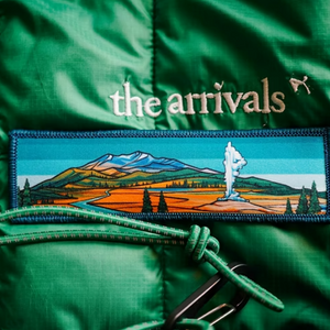 Green jacket featuring a Yellowstone mountain and landscape design.