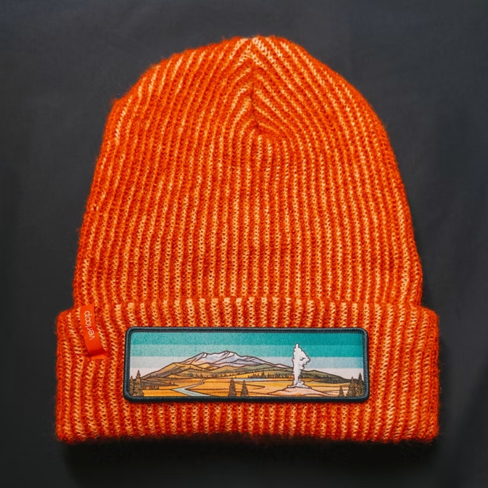 Orange knit beanie with a Yellowstone mountain patch on a black background