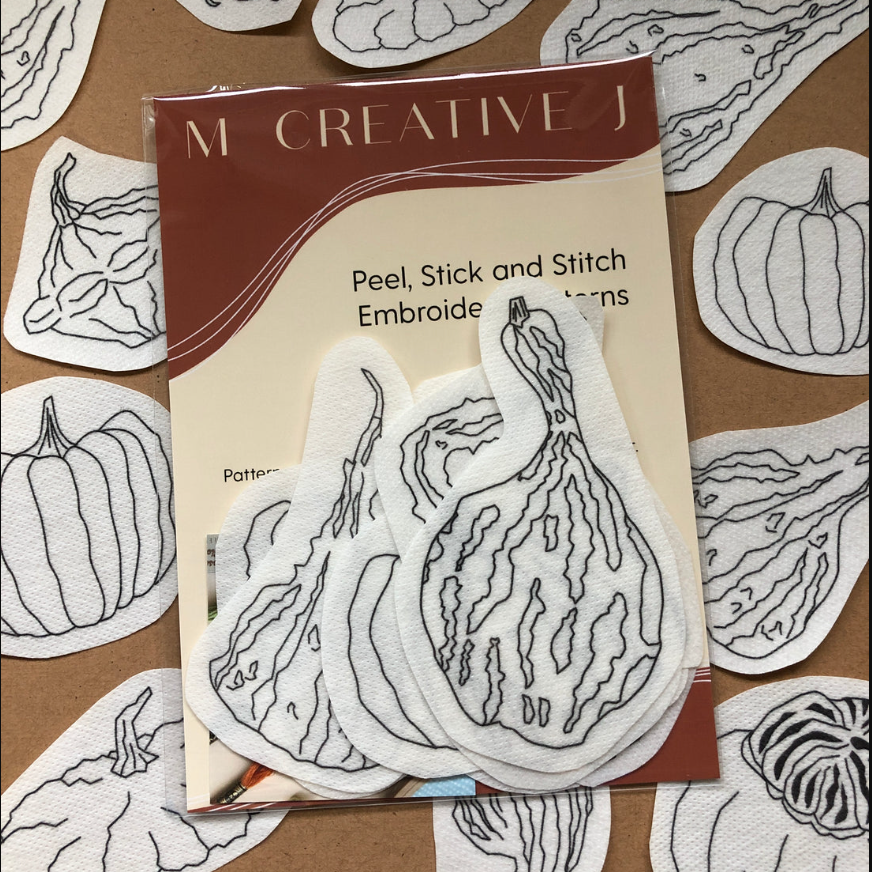 Packaging of M Creative J peel, stick, and stitch embroidery patterns with gourd designs on a brown background.