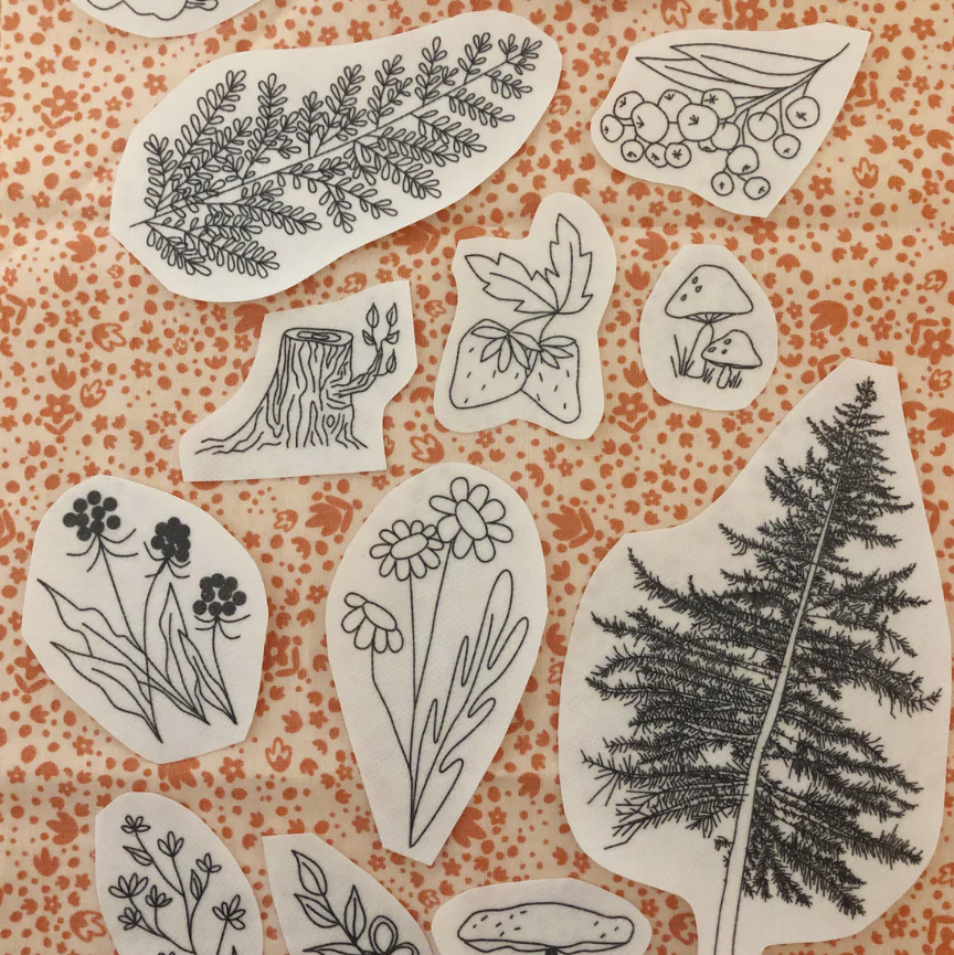 Set of black line art nature-themed embroidery stickers on a patterned background. 