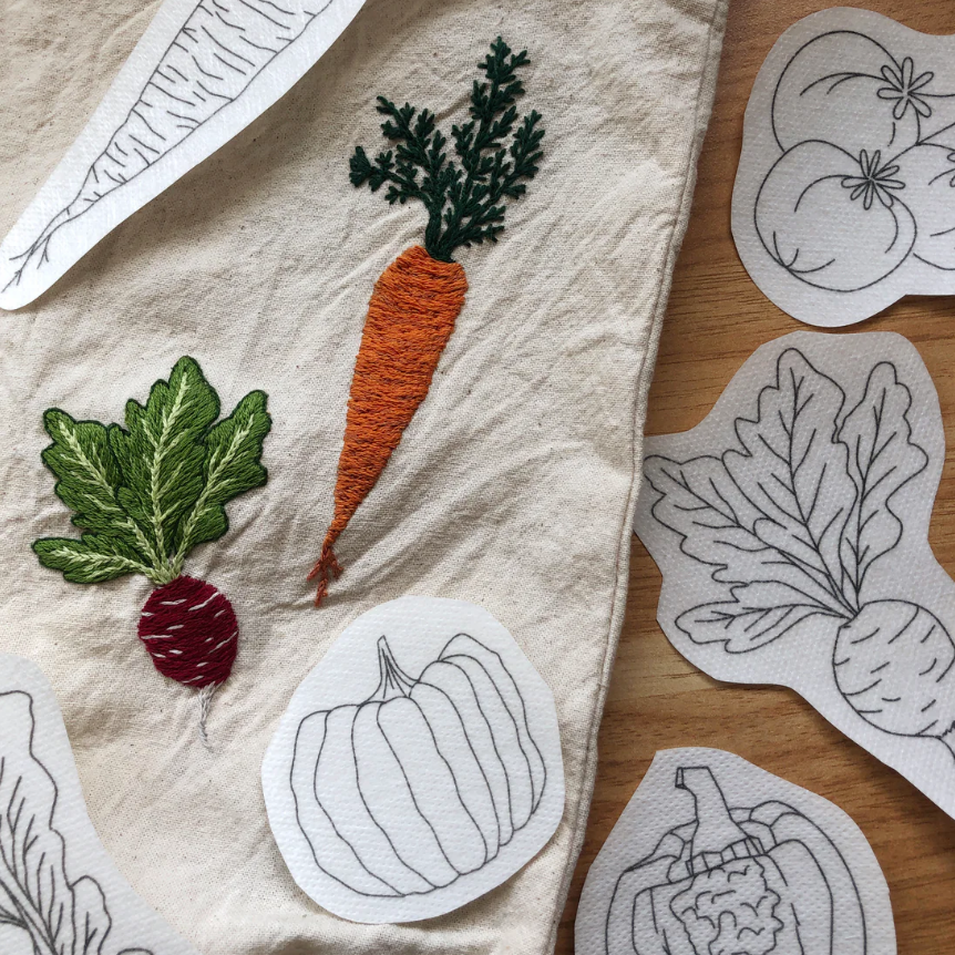 Embroidered vegetable patches on fabric and wooden surface. 