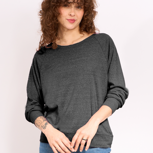 Woman wearing a dark gray long-sleeve top against a plain background. 