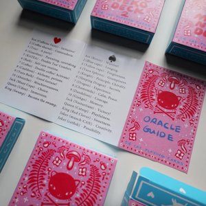 Card decks and Oracle Guide on a light surface. 