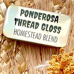 A metal tin of Ponderosa Thread Gloss - Homestead Blend - against a background of dried florals.