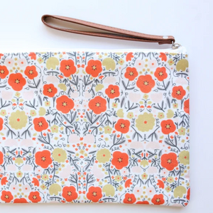 Floral patterned pouch with a strap on a white background