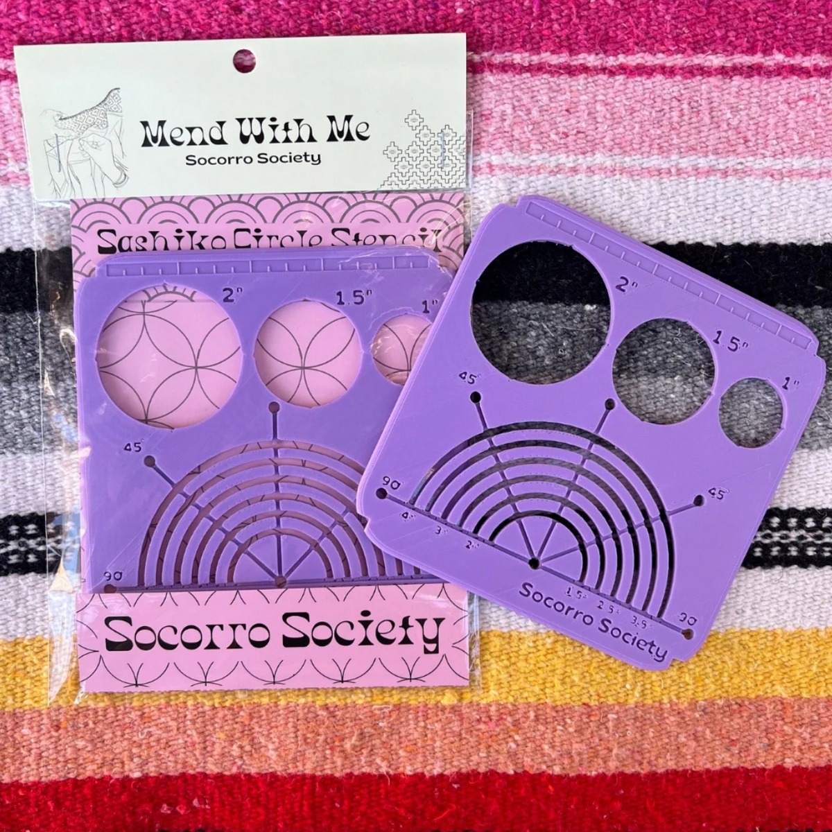 Purple embroidery stitch guide with packaging on a striped fabric background. 