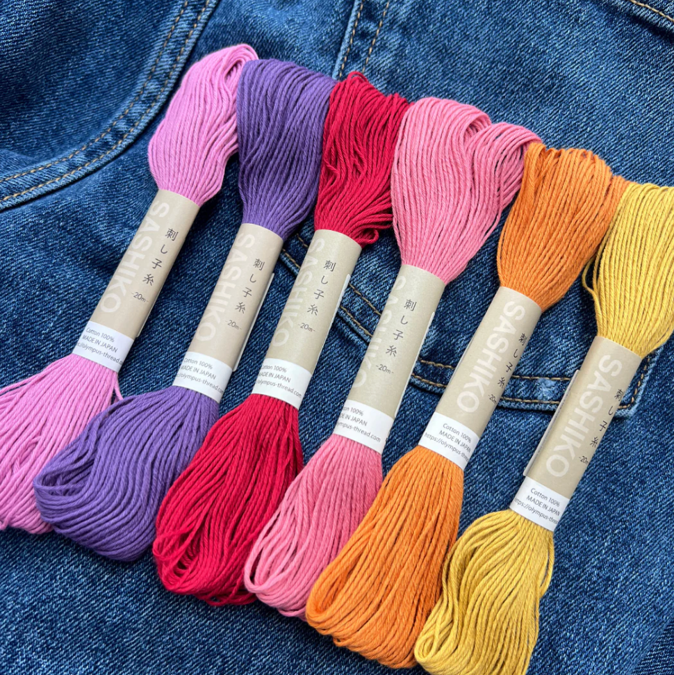 Set of colorful sashiko 100% cotton threads on a denim background. 
