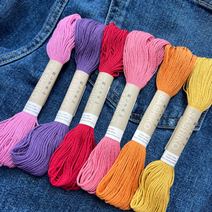 Set of colorful sashiko 100% cotton threads on a denim background. 