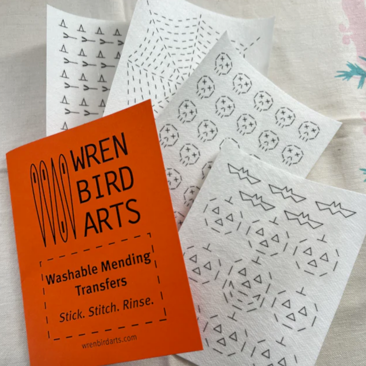 Photo shows four different Halloween themed Sashiko stitching designs. Witches hats and brooms, a spider web, skulls, bats and jack-o-lanterns. 