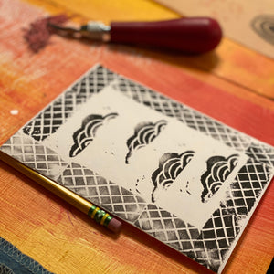 Decorative card with black and white patterns on a textured wooden surface.