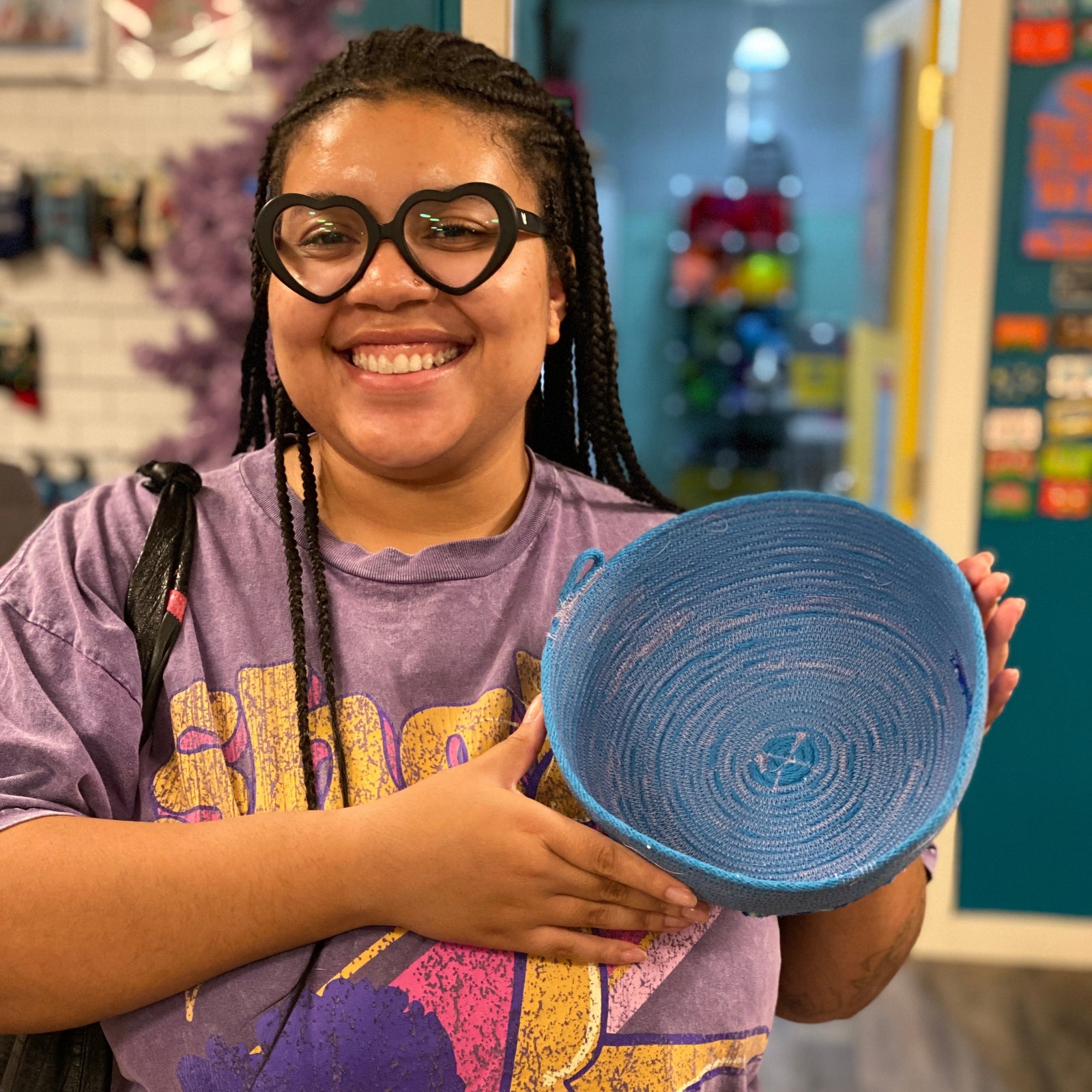 Person holding a blue rope bowl in an craft store setting. 