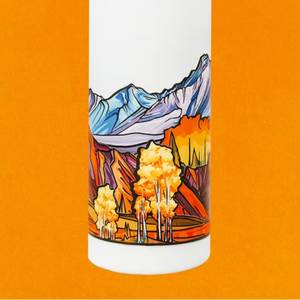 White water bottle with mountain and forest design on an orange background