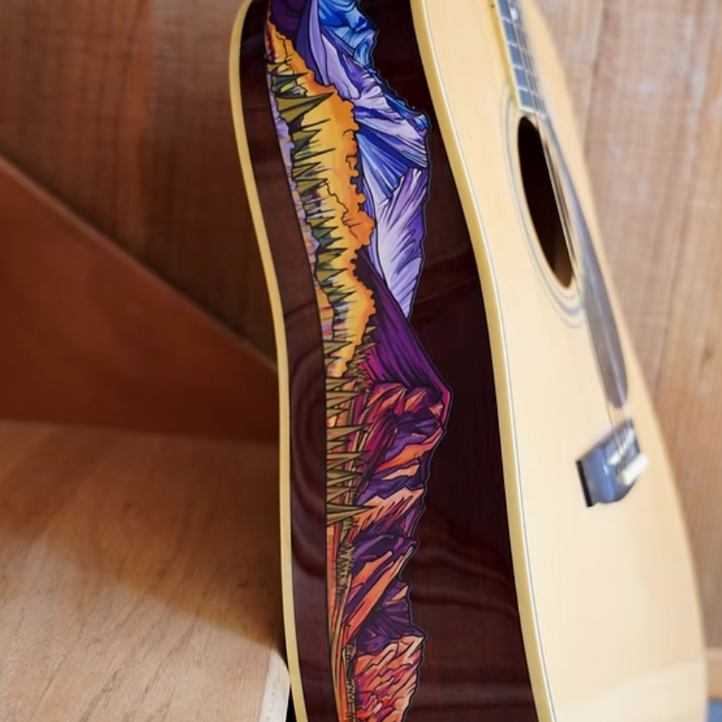 Acoustic guitar with a colorful Flat Irons mountain design on the side. 