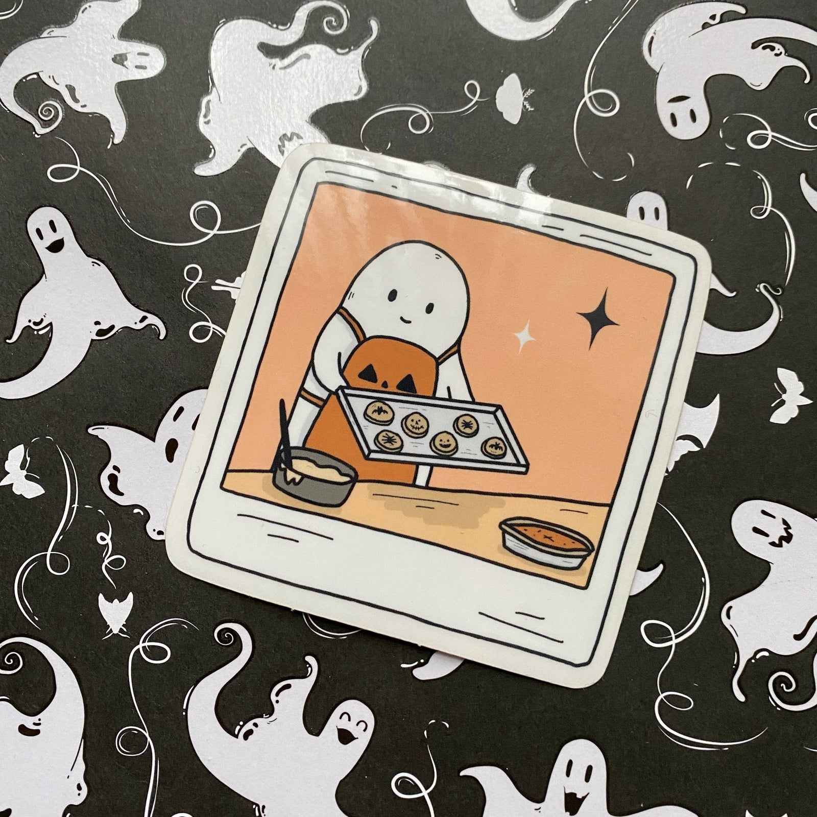 Illustration of a ghost baking cookies on a Halloween-themed background with ghosts.