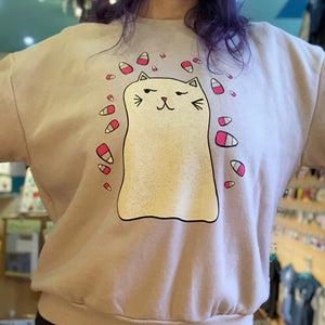 Person wearing a blush pink ghost kitty  sweatshirt. 