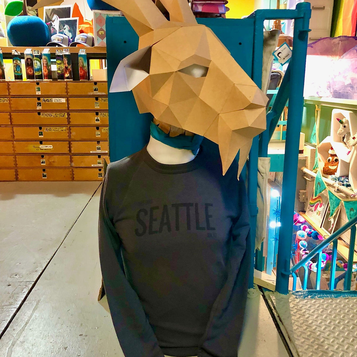 Person wearing a goat head mask and 'This Says Seattle on it' sweatshirt in a store setting. 