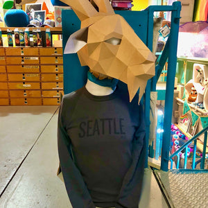 Person wearing a goat head mask and 'This Says Seattle on it' sweatshirt in a store setting. 