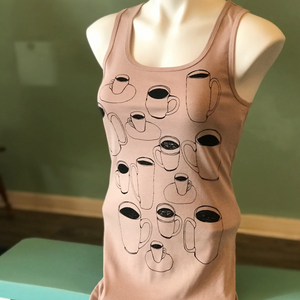 Beige tank top with coffee cup designs on a mannequin against a green wall.